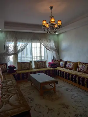 a living room with a couch and a table at Bel Appartement à Mansbay in Mansouria
