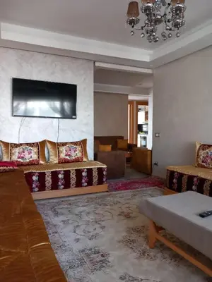 a living room with two couches and a tv at Bel Appartement à Mansbay in Mansouria
