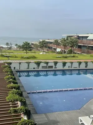 an overhead view of a large swimming pool with palm trees at Nice appartement pool & sea view in Dar Bouazza