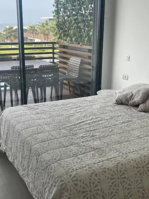 a bedroom with a bed and a table and chairs at Nice appartement pool & sea view in Dar Bouazza
