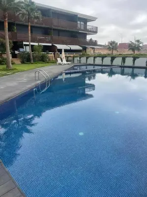 a large swimming pool in front of a building at Nice appartement pool & sea view in Dar Bouazza