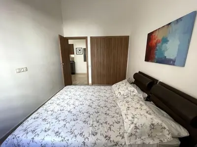 a bedroom with a bed with a floral bedspread at Luxury apartment 5 minutes Casablanca Airport in Nouaceur