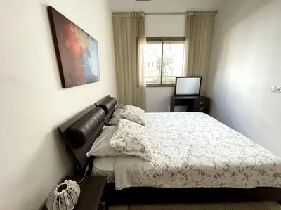 a bedroom with a bed and a television in it at Luxury apartment 5 minutes Casablanca Airport in Nouaceur