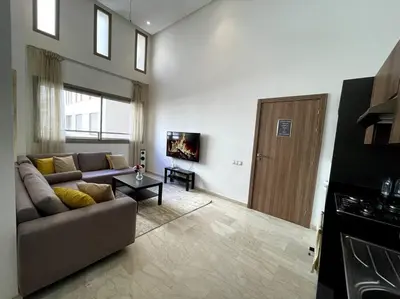 a living room with a couch and a table and a door at Luxury apartment 5 minutes Casablanca Airport in Nouaceur