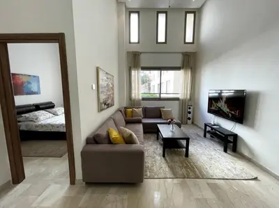 a living room with a couch and a bed at Luxury apartment 5 minutes Casablanca Airport in Nouaceur