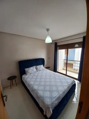 a bedroom with a large bed and a window at Ilyass Garden Beach Sidi Rahal in Dar Hamida