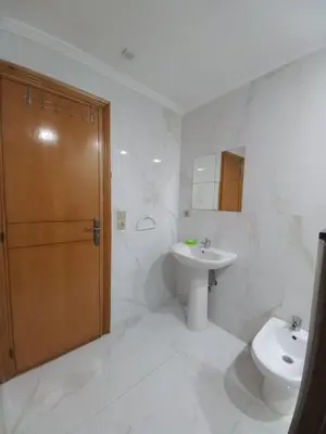 a bathroom with a toilet and a sink and a door at Ilyass Garden Beach Sidi Rahal in Dar Hamida