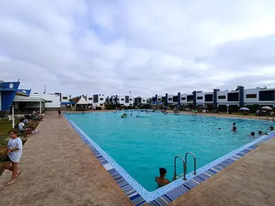 a large swimming pool with many people in it at Ilyass Garden Beach Sidi Rahal in Dar Hamida