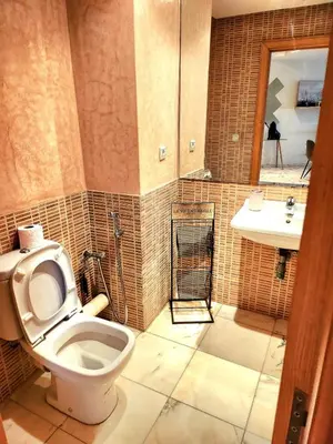 a bathroom with a toilet and a sink at La perle in Nouaceur
