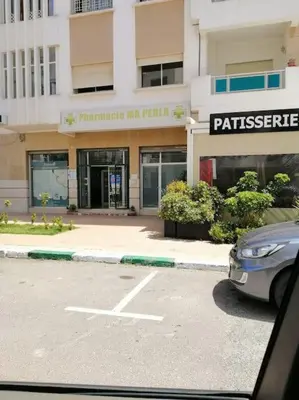 a car parked in a parking lot in front of a building at La perle in Nouaceur