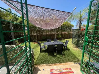 a patio with a table and chairs in a yard at BEAU TRIPLEX EN RESIDENCE in Skhirat