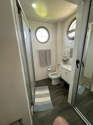 a bathroom with a toilet and a sink and a window at BEAU TRIPLEX EN RESIDENCE in Skhirat