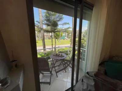 a room with a balcony with a table and chairs at BEAU TRIPLEX EN RESIDENCE in Skhirat