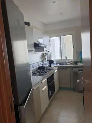 a kitchen with a stainless steel refrigerator and a sink at Luxueux appartement front mer in Sidi Rahal
