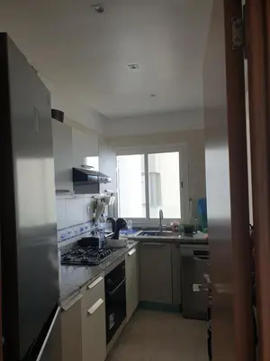 a kitchen with a sink and a stove top oven at Luxueux appartement front mer in Sidi Rahal