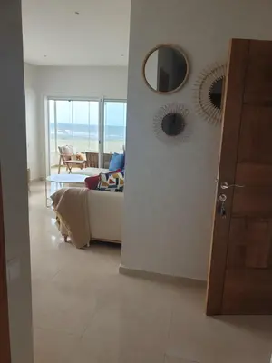 a living room with a couch and a table at Luxueux appartement front mer in Sidi Rahal