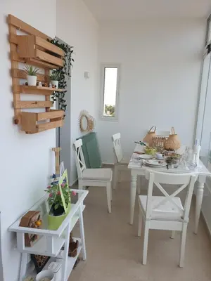a dining room with white tables and chairs at Luxueux appartement front mer in Sidi Rahal
