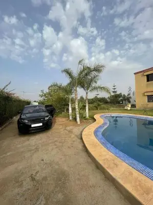 a car parked next to a swimming pool at Villa avec piscine et jardin privés in Casablanca