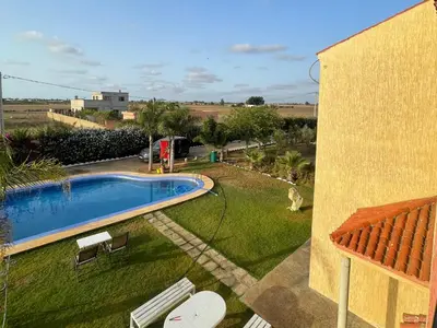 a swimming pool in a yard next to a building at Villa avec piscine et jardin privés in Casablanca