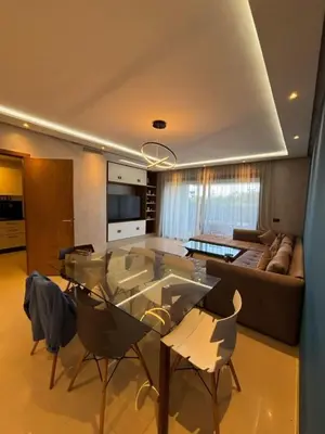 a living room with a glass table and a couch at Appartement meublé piscine Residence eden tamaris in Dar Bouazza