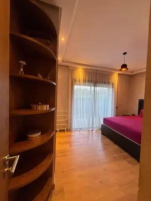 a bedroom with a bed and a book shelf at Appartement meublé piscine Residence eden tamaris in Dar Bouazza