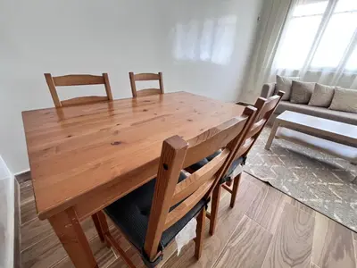 a wooden dining room table with chairs and a couch at Casablanca Beautiful and Tranquil Family Apartment in Casablanca