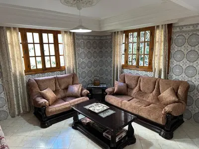 a living room with two couches and a coffee table at Rez-de-jardin à Mohammedia in Mohammedia