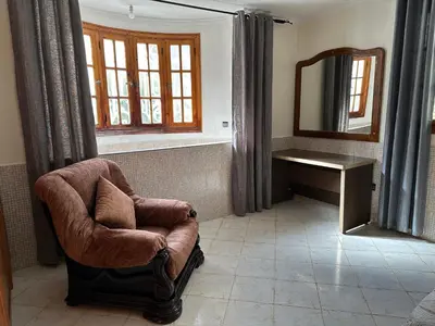 a bathroom with a chair and a desk and a mirror at Rez-de-jardin à Mohammedia in Mohammedia
