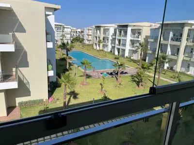 a view of a pool from a balcony of a building at Appartement à Casabay SidiRahal in Sidi Rahal
