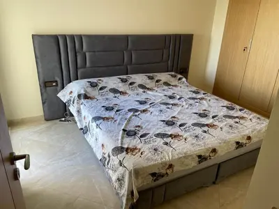 a bedroom with a bed with a black headboard at Appartement à Casabay SidiRahal in Sidi Rahal
