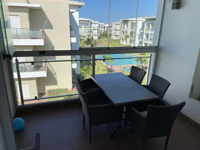 a table and chairs in a room with a large window at Appartement à Casabay SidiRahal in Sidi Rahal