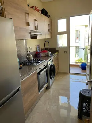 a kitchen with a stove and a washing machine at Appartement à Casabay SidiRahal in Sidi Rahal