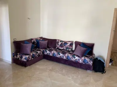 a couch sitting in a living room with purple pillows at Appartement à Casabay SidiRahal in Sidi Rahal