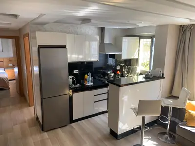a kitchen with a refrigerator and a counter top at La location de la mer in Dar Bouazza