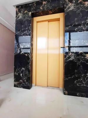 a yellow door in a room with a black wall at La location de la mer in Dar Bouazza