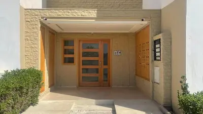 an entrance to a building with a wooden door at La location de la mer in Dar Bouazza