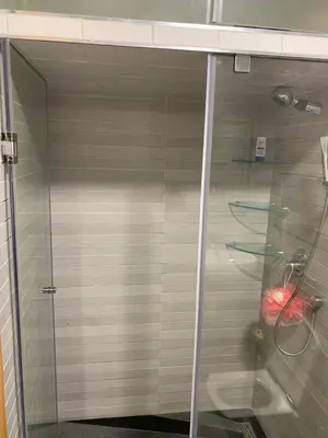a shower with a glass door in a bathroom at La location de la mer in Dar Bouazza