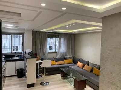 a living room with a couch and a table at La location de la mer in Dar Bouazza