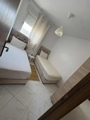 a small room with two beds and a window at perle de bouznika 15min walking to the beach plus free unlimited WiFi in Bouznika