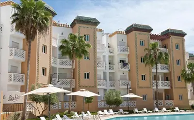 a hotel with a swimming pool in front of a building at Résidence Al Kawtar- Mansouria Mohammedia in Mohammedia