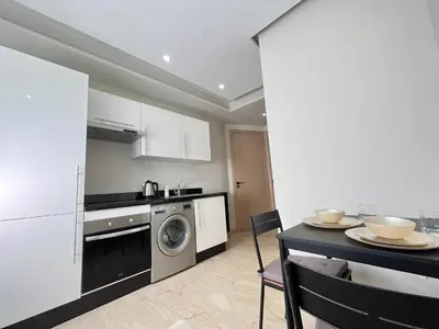 a kitchen with a washing machine and a table with chairs at Comfy & Modern Studio at blv Anfa in Casablanca