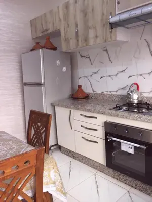 a kitchen with a stove and a refrigerator at Sweet Room Airport 5 in Deroua