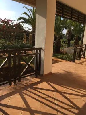 a porch with a wooden fence and palm trees at BOUZNIKA BAY COUNTRY CLUB in Bouznika