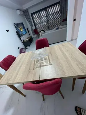 a wooden table with red chairs in a room at Étoile Harhoura in El Harhoura