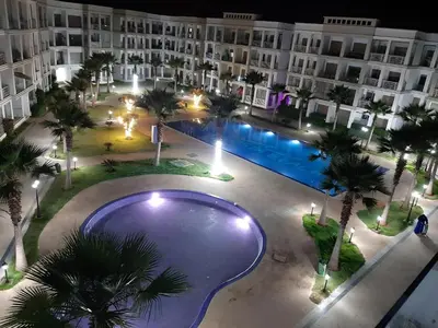 an overhead view of a pool with palm trees and buildings at COSTA BEACH Lux Family Apartment with Pools in Bouznika