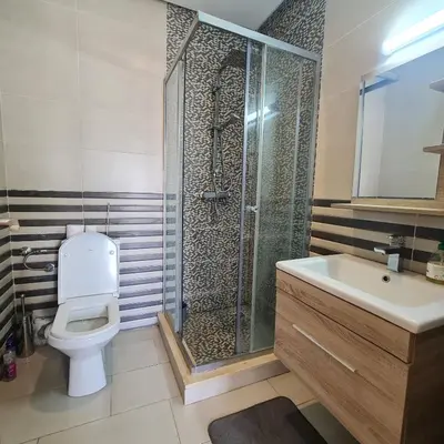 a bathroom with a shower and a toilet and a sink at COSTA BEACH Lux Family Apartment with Pools in Bouznika