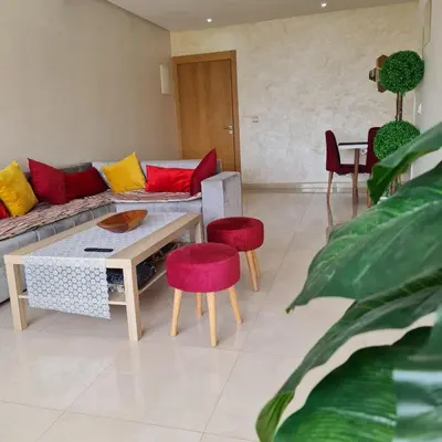 a living room with a couch and red and yellow pillows at COSTA BEACH Lux Family Apartment with Pools in Bouznika