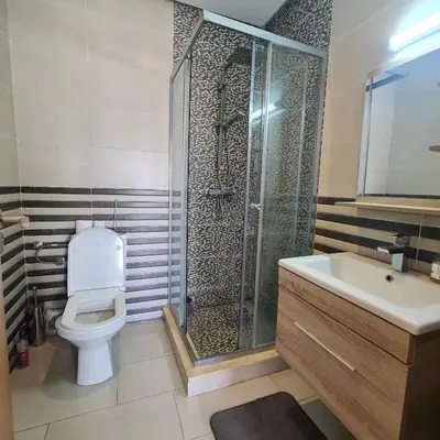 a bathroom with a shower and a toilet and a sink at COSTA BEACH Lux Family Apartment with Pools in Bouznika
