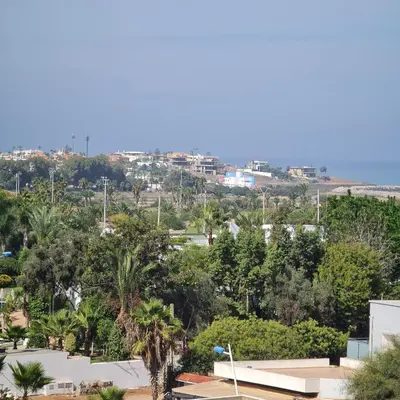 a view of a city with trees and the ocean at COSTA BEACH Lux Family Apartment with Pools in Bouznika