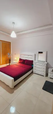 a bedroom with a large bed and a dresser at COSTA BEACH Lux Family Apartment with Pools in Bouznika